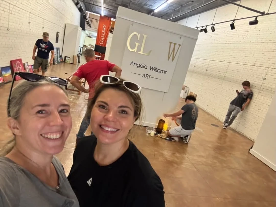 Two women taking a selfie while the GLOW display is being set up.